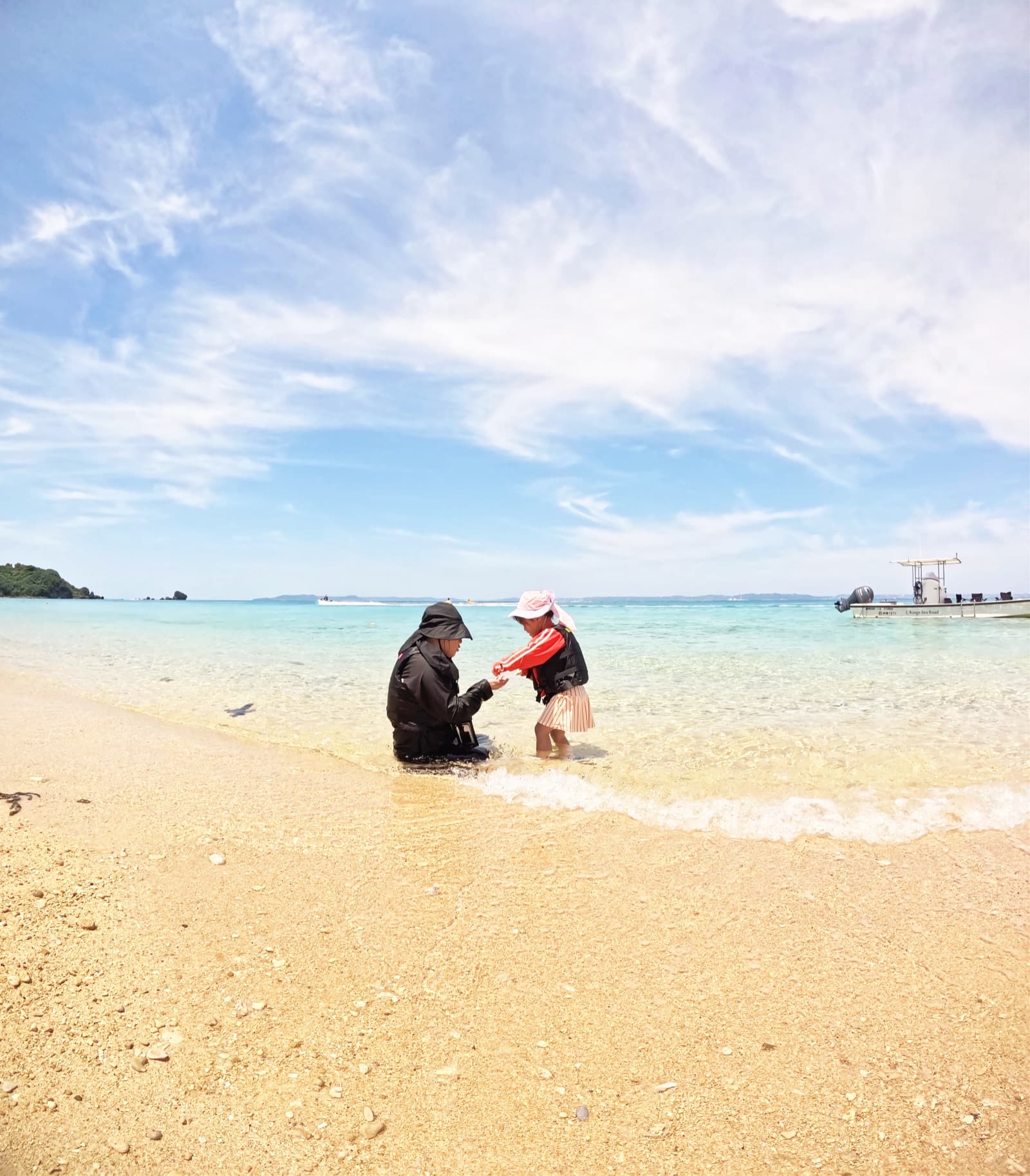 無人島の浅瀬で遊ぶ家族